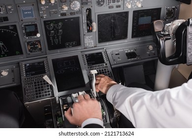 High Angle View Of Pilot Using Thrust Lever Near Co-pilot In Airplane Simulator