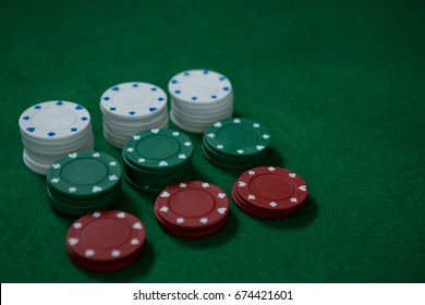 High Angle View Of Poker Chips On Green Table