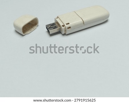 High angle view of portable cell broadband network dongle for computer digital connection on white backdrop.