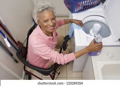 High Angle View Portrait Of An African American Woman On Wheel Chair Washing Clothes