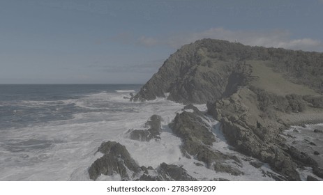 High angle view of powerful ocean waves hitting the rocky coastline of Byron Bay.