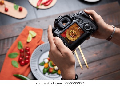 High angle view of professional photographer making photo of food on digital camera - Powered by Shutterstock