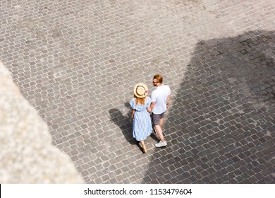 High Angle View Of Redhead Couple Holding Hands And Walking At City Street