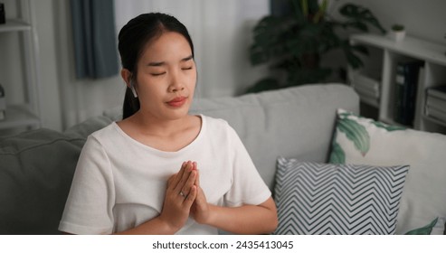 High angle view, Relaxed young woman wear wireless headphones enjoying rest on sofa in living room, breathing fresh air with eyes closed, meditating at home