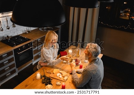 High angle view of romantic date of a married mature couple in the kitchen. Spouses, wife and husband, girlfriend and boyfriend celebrating with wine special event, anniversary, Valentine`s Day