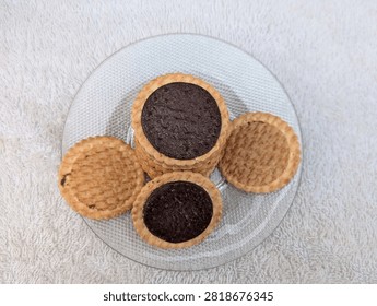 High angle view of round chocolate filled cookies served on a clear glass plate