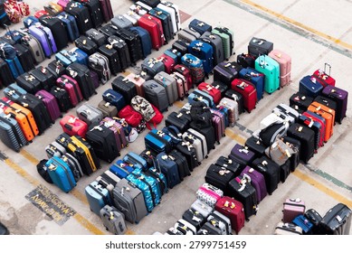 High angle view of rows of aligned suitcases and luggage on a port pier waiting for passengers