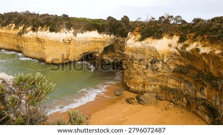 High angle view of rugged limestone cliffs surrounding a secluded sandy beach and cove.