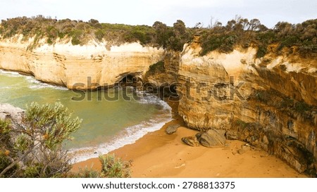 High angle view of rugged sandstone cliffs surrounding a secluded sandy beach and cove.