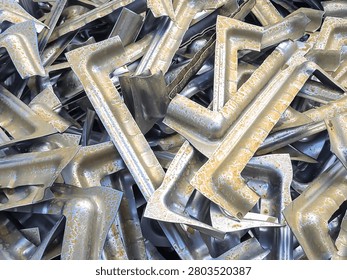 High angle view of rusted and corroded aluminium stamping parts piled in an industrial scrap yard for metal recycling