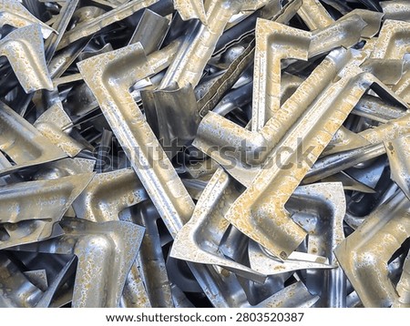 High angle view of rusted and corroded aluminium stamping parts piled in an industrial scrap yard for metal recycling