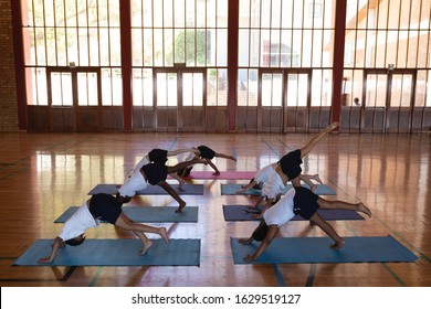 High angle view of schoolkids doing yoga position on a yoga mat in school gymnast - Powered by Shutterstock