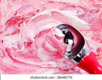 High Angle View Of Scoop Scooping A Serving Of Pink Berry Swirl Ice Cream