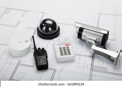 High Angle View Of Security Equipment On Blueprint In Office