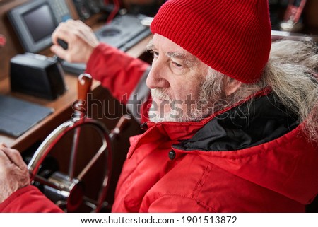 High angle view of the senior man sailing in the sea. Yacht skipper standing at the steering wheel. Sailing at the luxury yachts concept. Stock photo