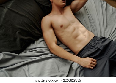 High Angle View Of Sexy Shirtless Man In Pajama Pants Lying On Bed At Home