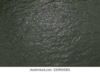 High angle view of the shining waves of the dark water surface of the Black river (The Kalu river) in Sri Lanka .This shining view of the water surface causes by the sun rays of the sunset