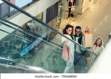 High Angle View Of Shoppers Riding Escalator At Mall