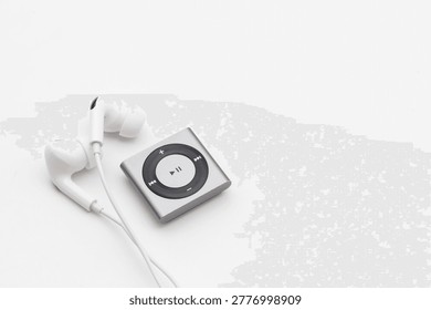 High angle view of silver Mp3 Player with white wired earbuds on white background