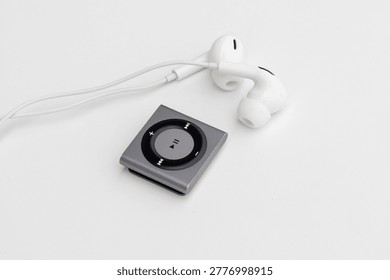 High angle view of silver Mp3 Player with white wired earbuds on white background
