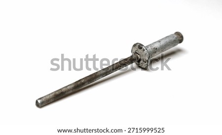 High angle view of a single weathered rusty pop rivet isolated on a white background.