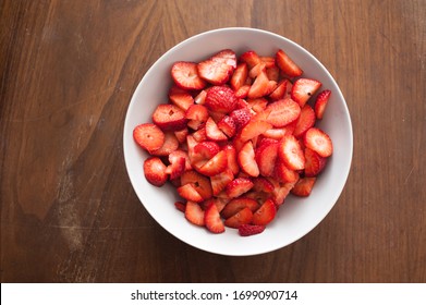 high angle view of sliced straberries in a white plate. Great copy space