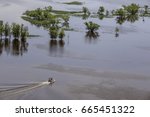 High angle view of small boat motoring toward lowland area flooded by the Upper Mississippi River near McGregor, Iowa, on a spring morning, for recreational, boating and environmental themes