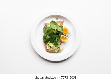 High Angle View Of Smashed Avocado, Spinach On Toast With Boiled Egg