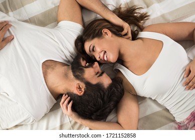 High angle view of smiling couple relaxing and lying down in bed .They are looking at each other - Powered by Shutterstock