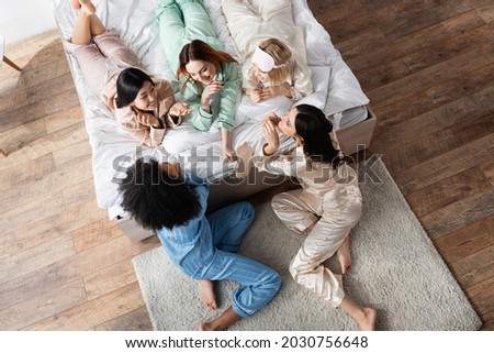 high angle view of smiling interracial women talking during slumber party