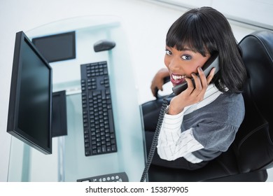 High angle view of smiling pretty businesswoman on the phone in bright office