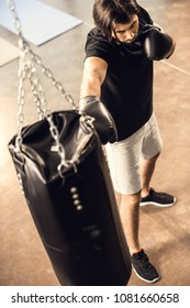 High Angle View Of Sporty Young Man Boxing With Punching Bag In Gym 