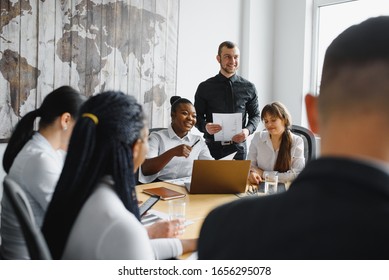 High angle view of successful young business people using gadgets, sharing ideas and smiling while working in office - Shutterstock ID 1656295078