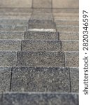 High angle view of textured grey stone steps going up with selective focus creating depth of field in vertical orientation