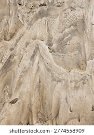 High Angle View of Textured Sandy Ground with Ripple Patterns and Footprints