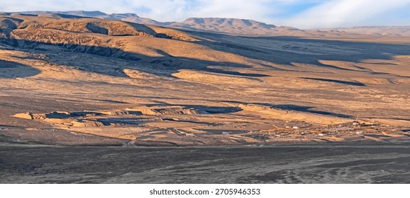 High angle view of Thacker Pass in Nevada, USA, shows an expansive lithium mine. The landscape is vast with earthy tones, featuring excavation sites and machinery.