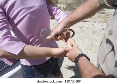 High Angle View Of Traffic Cop Arresting Young Woman