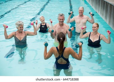 High angle view of trainer and senior swimmers exercising in swimming pool  - Powered by Shutterstock - Get 15% off with code: PIKWIZARD15
