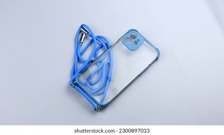 High angle view of transparent mobile phone case with colorful strap. Isolated on white background.