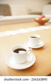 High angle view of two cups of black tea with saucers on a table