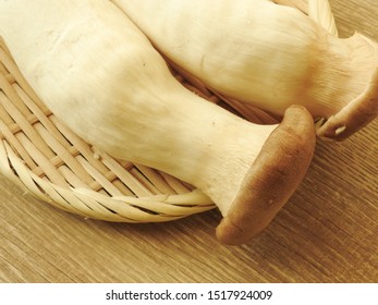 High Angle View Of Two Fresh Raw King Oyster Mushrooms On Bamboo Plate On Wooden Background. With Low Calorie, High Protein, High Fiber Food, Rich In Vitamin B2. Full Of Nutrition. Cooking Ingredients