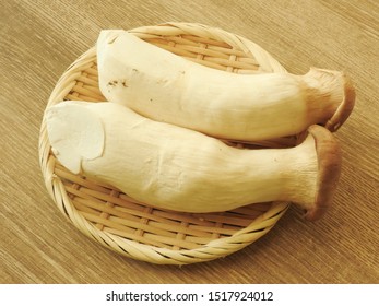 High Angle View Of Two Fresh Raw King Oyster Mushrooms On Bamboo Plate On Wooden Background. With Low Calorie, High Protein, High Fiber Food, Rich In Vitamin B2. Full Of Nutrition. Cooking Ingredients