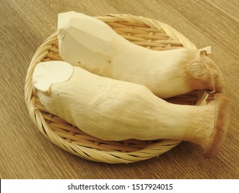 High Angle View Of Two Fresh Raw King Oyster Mushrooms On Bamboo Plate On Wooden Background. With Low Calorie, High Protein, High Fiber Food, Rich In Vitamin B2. Full Of Nutrition. Cooking Ingredients