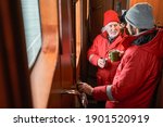 High angle view of the two handsome men talking at lunch. Two confident fishermans discussing work inside of the boat while drinking tea or coffee. Stock photo