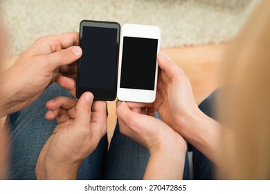 High Angle View Of Two People Holding Mobile Phones