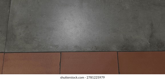 High angle view of two tone floor tiles background. Split composition of grey concrete and red terracotta tile texture.