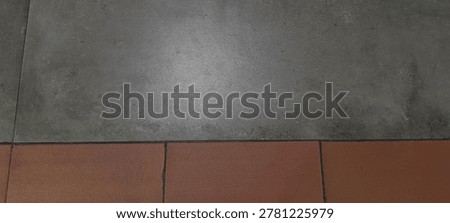 High angle view of two tone floor tiles background. Split composition of grey concrete and red terracotta tile texture.