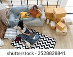 High angle view,  Two Young Asian Women Packing preparing to travel and Relaxing with smartphone, selfie together in Living Room