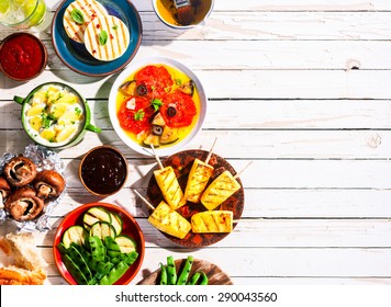 High Angle View of Vegetarian Mediterranean Meal of Grilled Fruit and Vegetables Spread Out on White Wooden Picnic Table with Copy Space