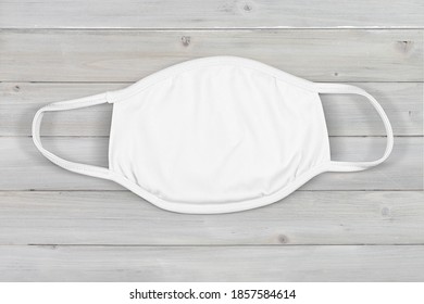 High Angle View Of A White Cloth Mask On A Modern Gray Wood Background.